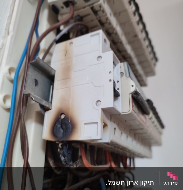 לוח חשמל עם סימני שריפה על מפסק